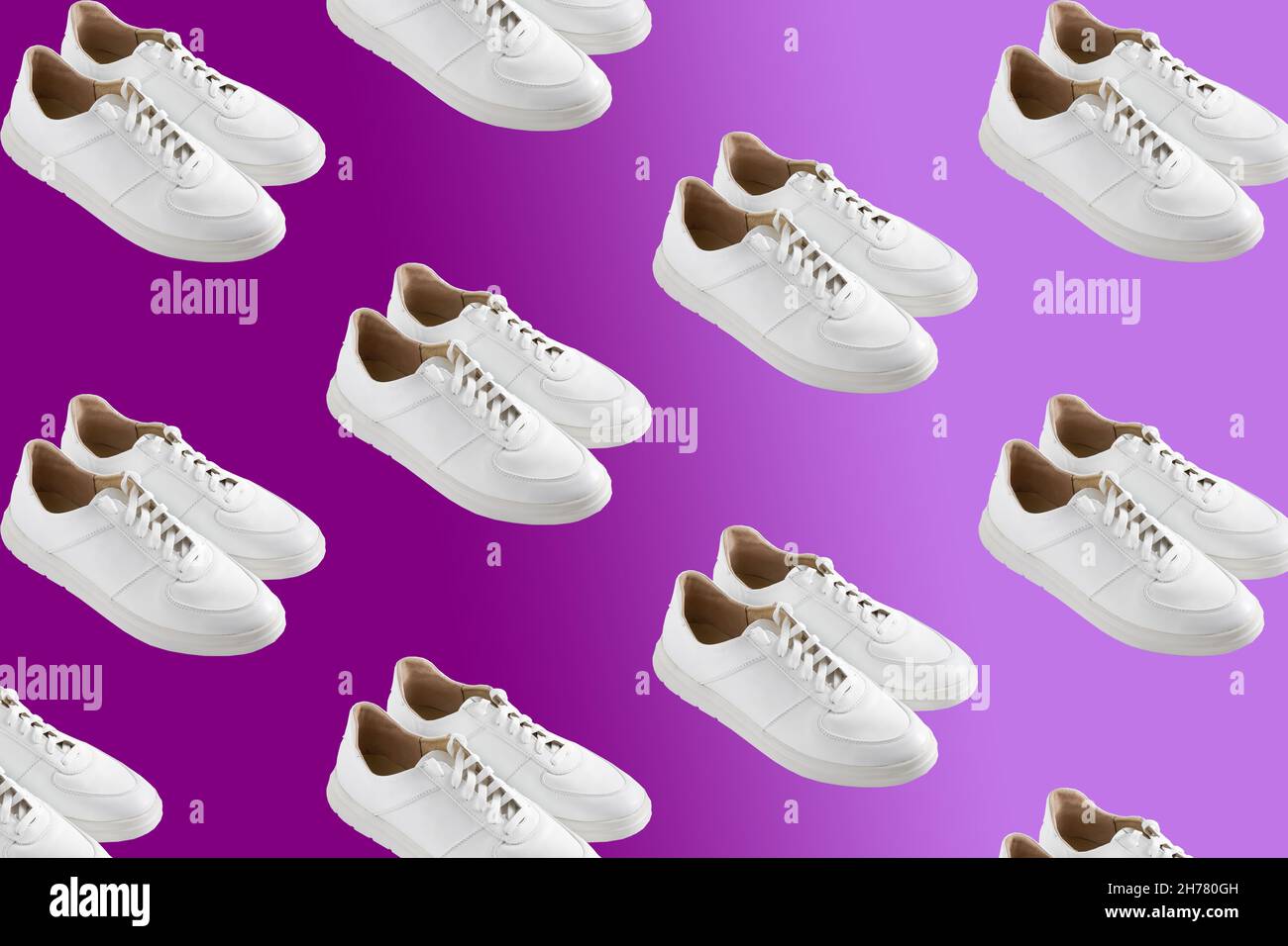 Sneakers bianche su sfondo viola velluto. Le scarpe sono comode e casual. Sfondo per un negozio di scarpe. Un paio di scarpe nuove. Foto Stock