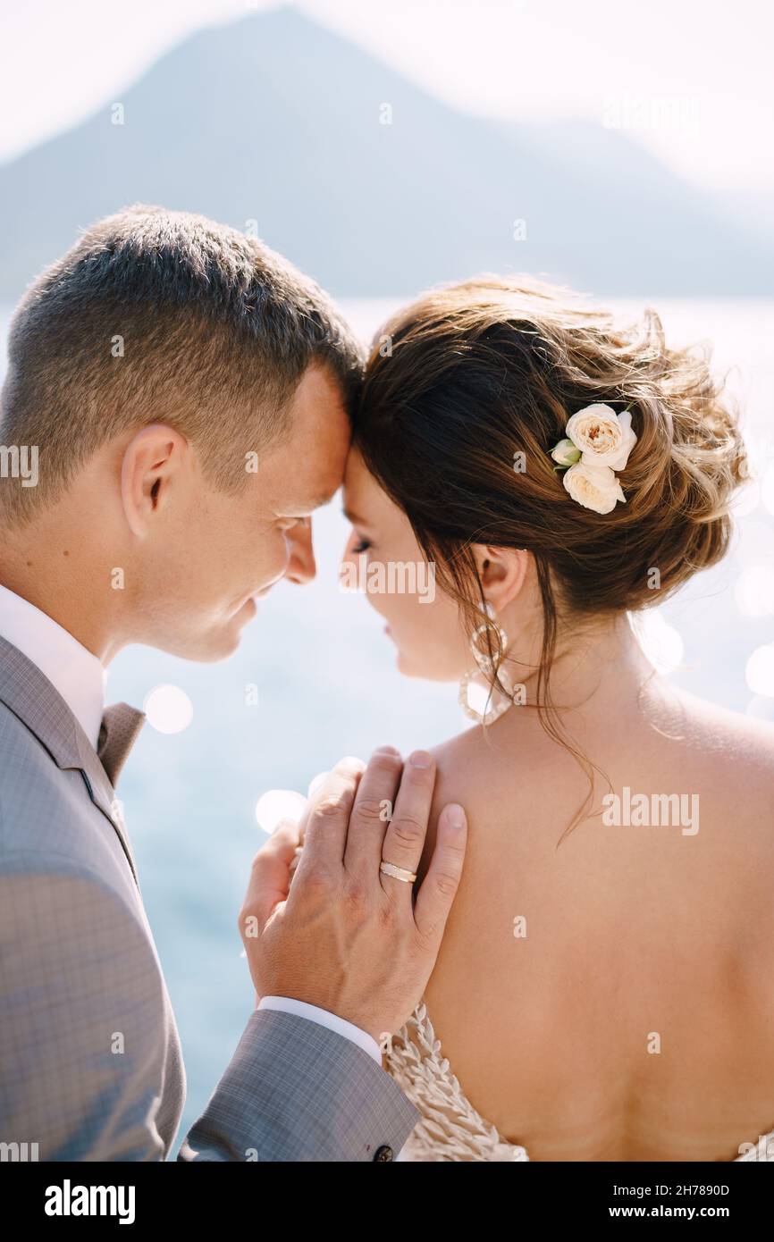 Lo sposo appoggiò la fronte contro la fronte della sposa e mise la mano sulla spalla Foto Stock