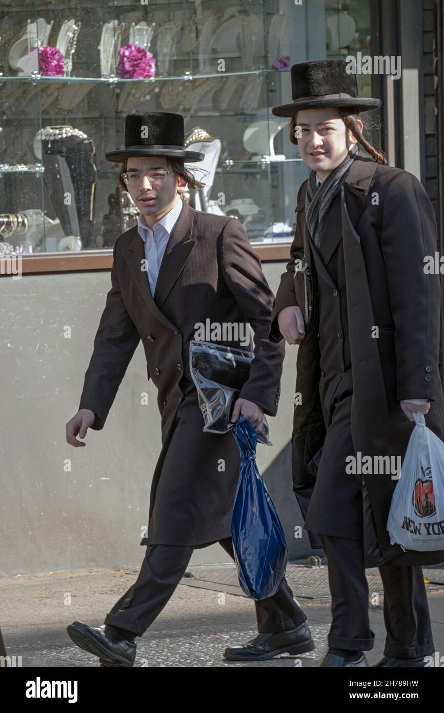 2 ragazzi ebrei ortodossi vestiti in modo molto simile, probabilmente adolescenti, camminano su Lee Avenue il venerdì pomeriggio. A Williamsburg, Brooklyn, New York. Foto Stock