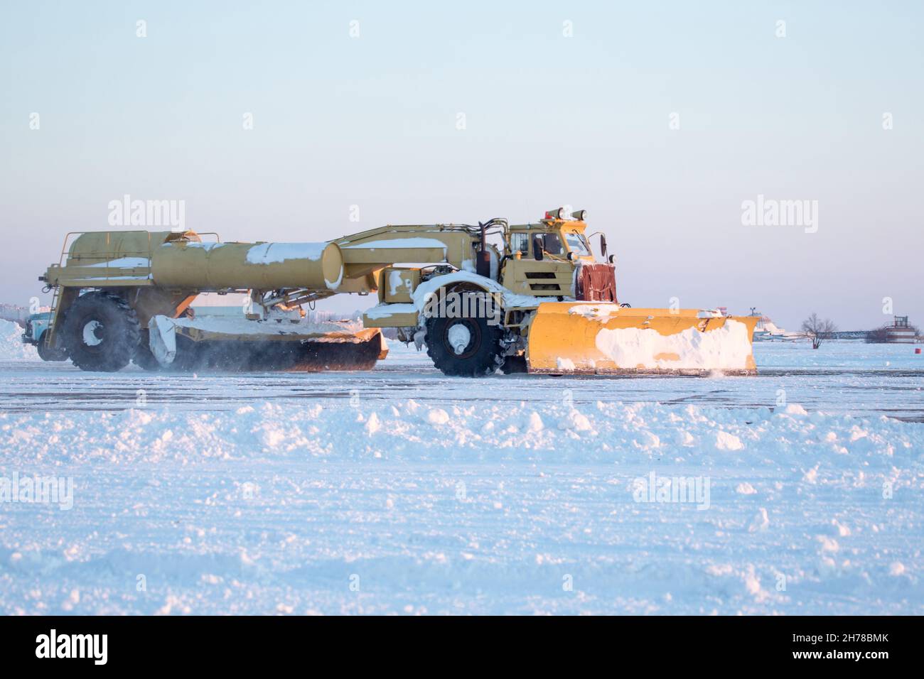 Pulizia aeroporto dalla neve durante la tempesta di neve. Pulizia pista dalla neve. Sgombrare la neve con i bulldozer dai grembiuli dell'aeroporto. Foto Stock