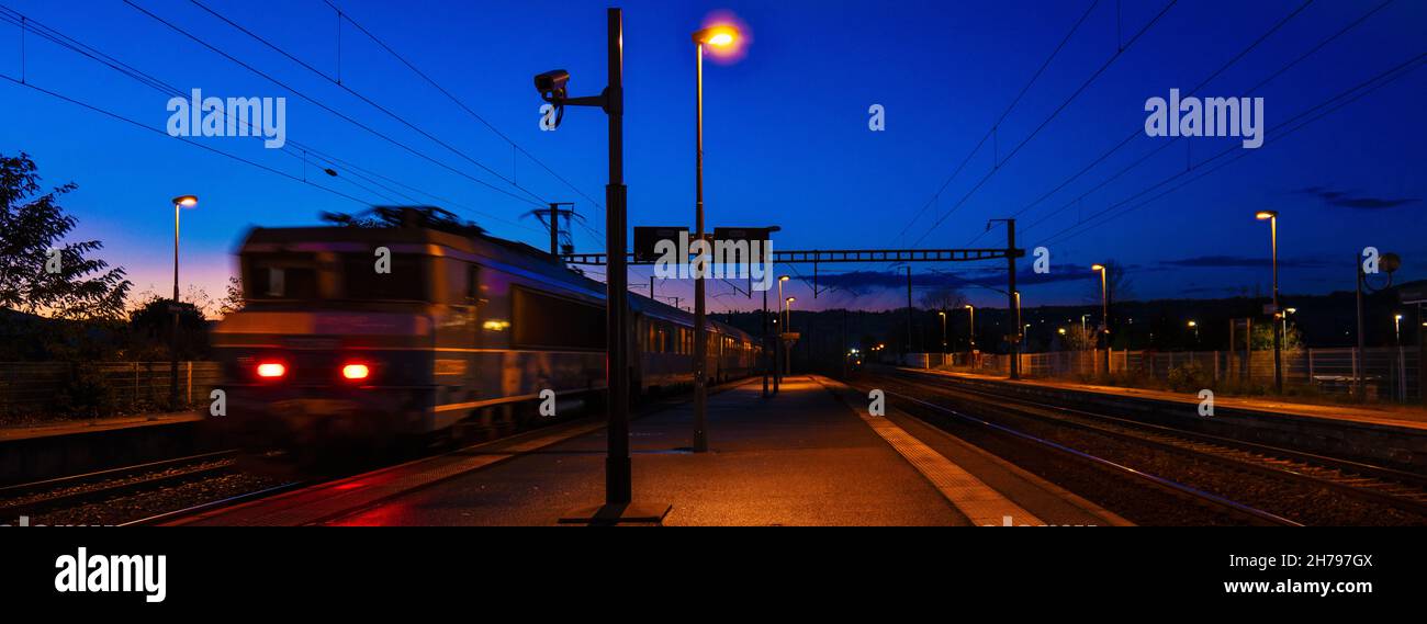 Treno che parte al tramonto Foto Stock