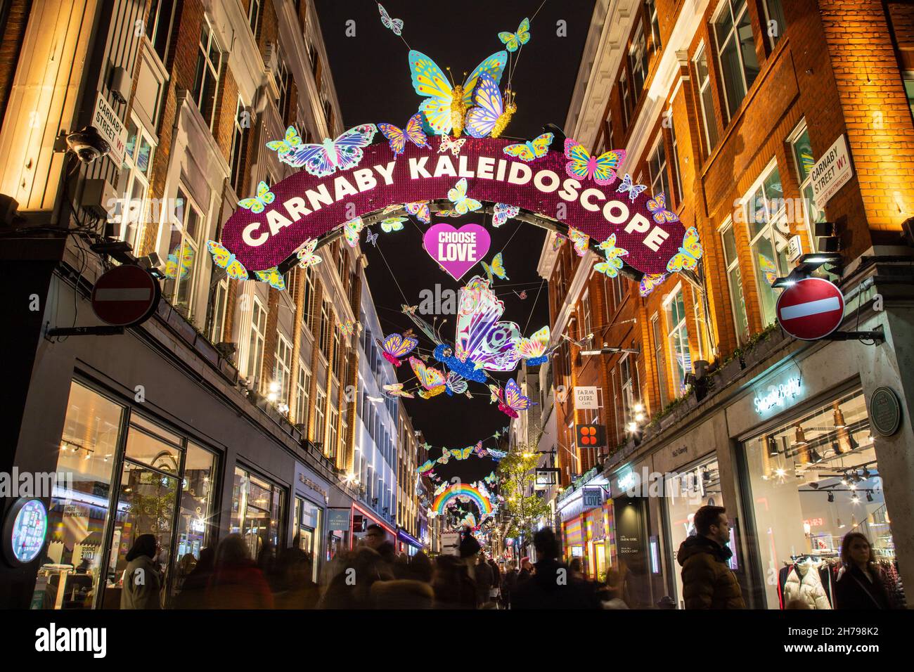 LONDRA, UK - 20 NOVEMBRE 2021: Viste lungo Carnaby Street a Londra a Natale mostrando le decorazioni e fuori dei negozi. Le persone possono essere viste all'esterno Foto Stock