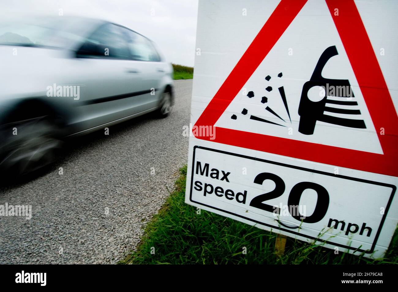 L'auto supera una velocità massima temporanea di 20 mph e segnala la presenza di schegge allentate su una strada di campagna B, Leicestershire, Inghilterra, Regno Unito. Foto Stock