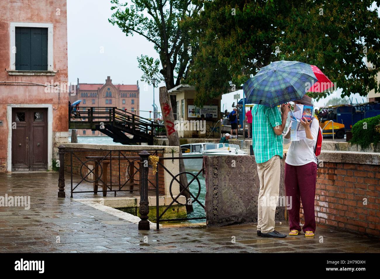 I turisti consultano la loro mappa in the rain, Dosoduro, Venezia, Italia. Foto Stock
