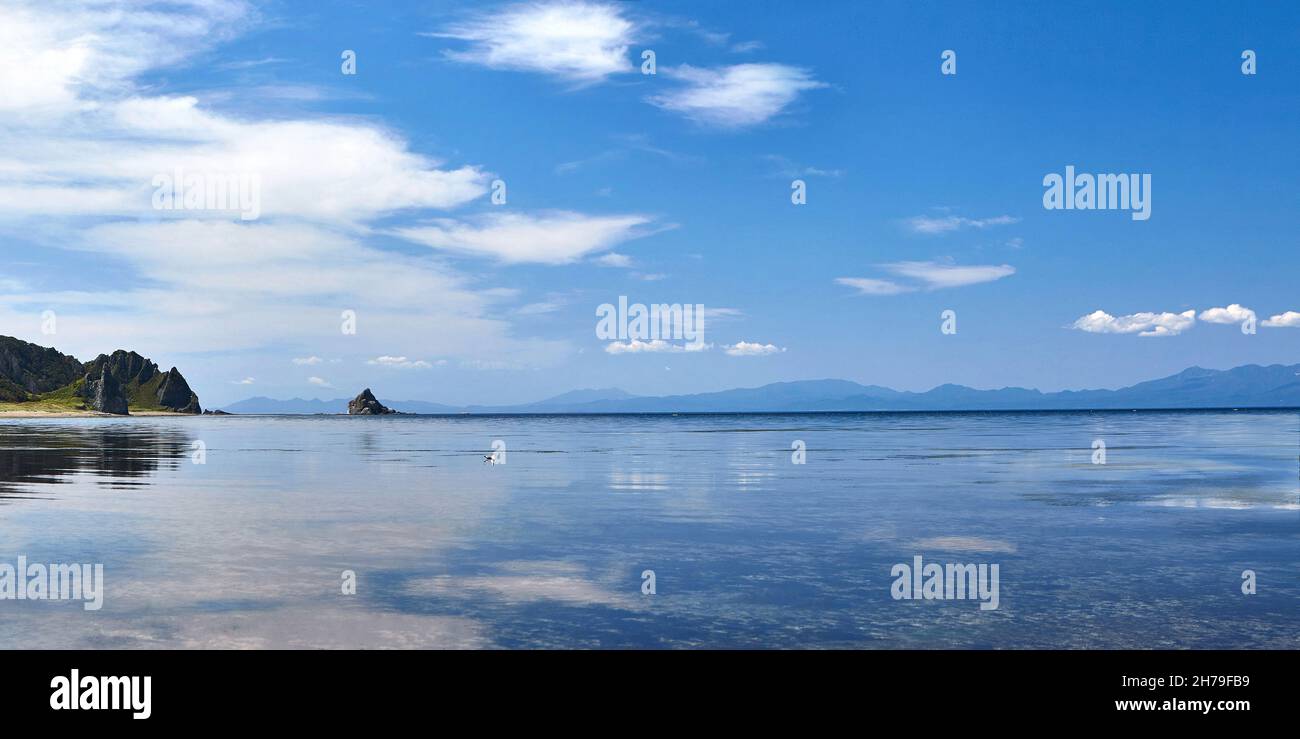 Serenity Morning view of low marea with mirror reflection Sky on surface of water..Kunashir Island of Kuril Chain. Russia Foto Stock