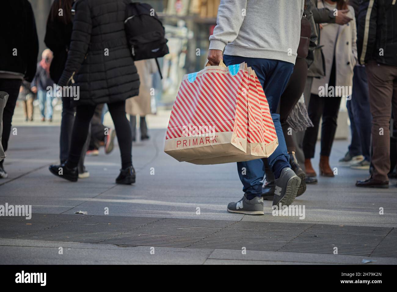 Uomo che trasporta le borse Primark a Callao (Madrid, Spagna). Foto Stock