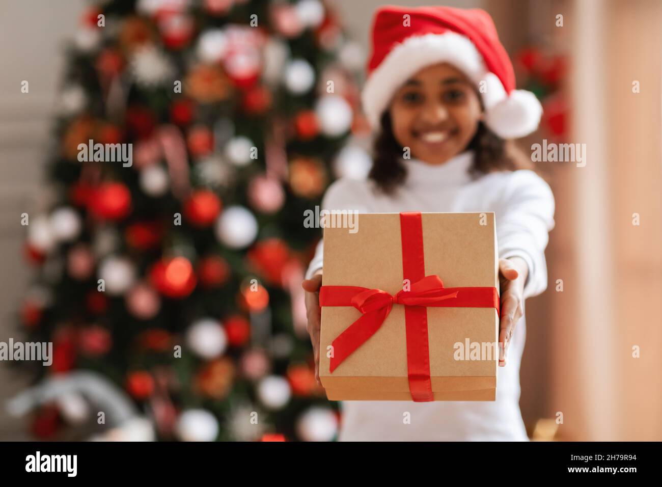 Happy Black Girl Holding regalo di Natale a casa Foto Stock