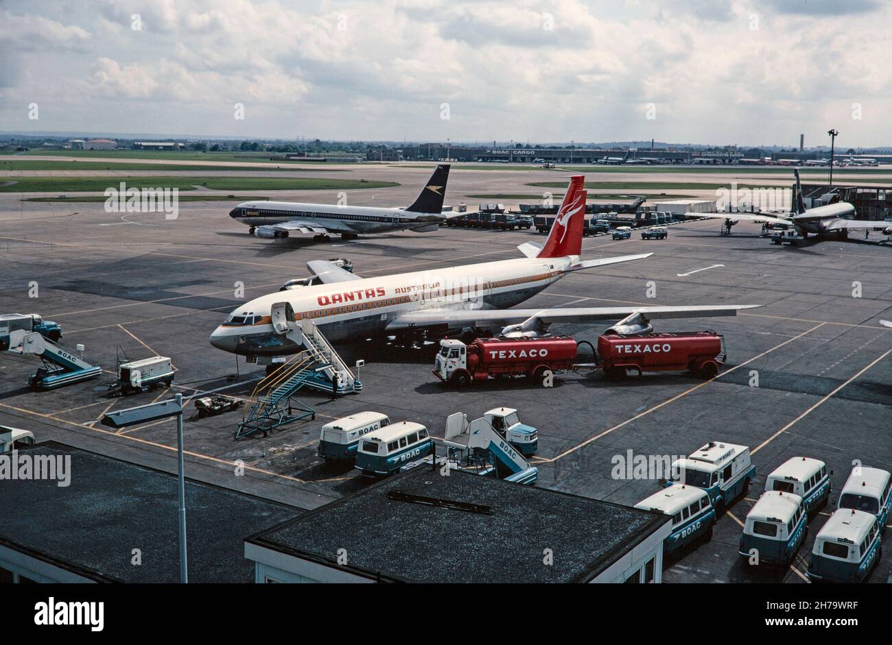 Una foto d'epoca a 1968 colori scattata all'aeroporto di Heathrow, che mostra un Boeing Qantas 707, numero di serie VH-EAC, e un Boeing BOAC 707, numero di serie G-APFJ. L'aeromobile Qantas viene rifornito da due petroliere Texaco. Foto Stock