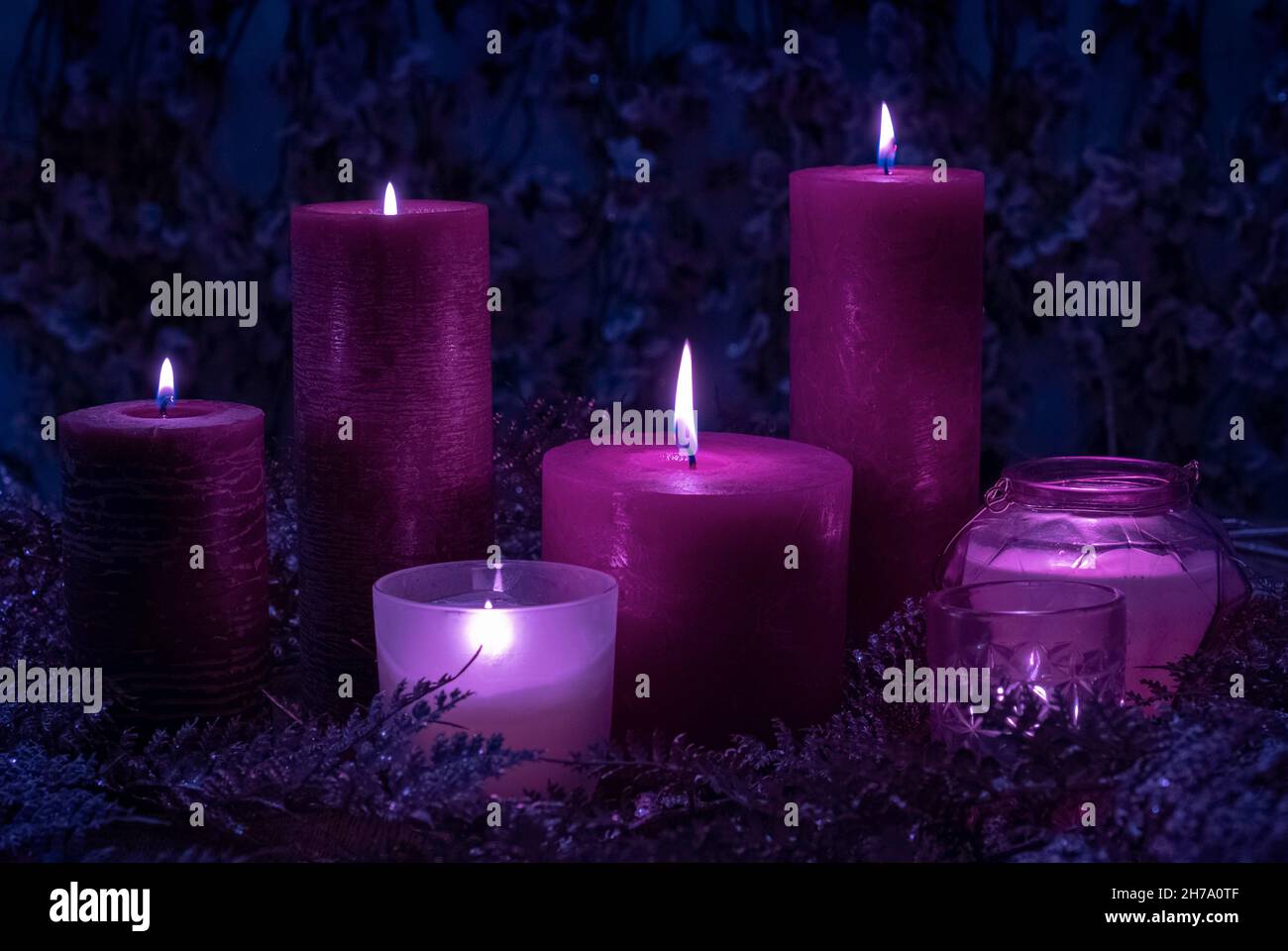 Un sacco di magia viola e velluto viola colori candele bruciare su sfondo  blu con fiori Foto stock - Alamy