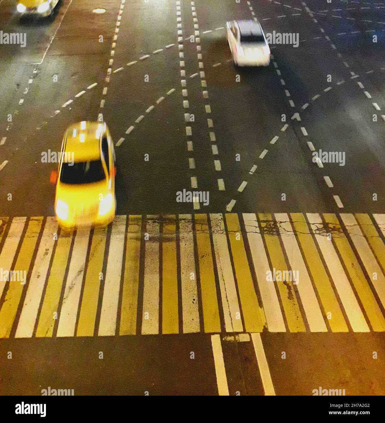 Bella foto d'arte dall'alto di taxi giallo che guidano lungo la strada notturna. Foto Stock