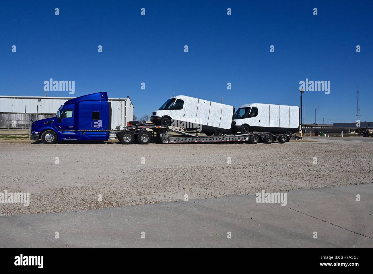 Due nuovissimi modelli EDV 500 Rivian Electric Delivery Vans (EDV) parte  della flotta ordinare per Amazon sul retro di un mezzo di trasporto Lowboy  camion parcheggiato nel Knights Inn Motel durante il