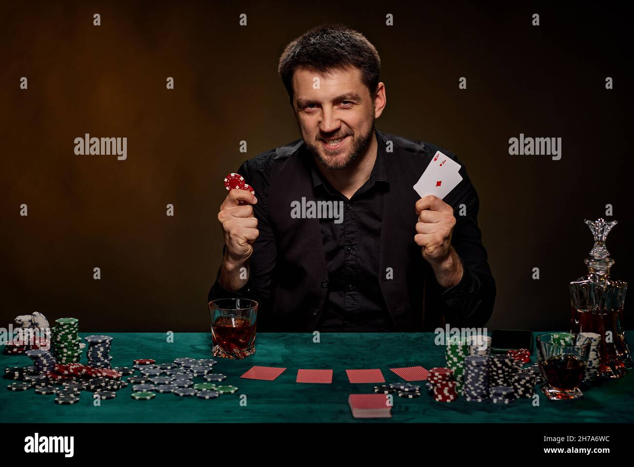 Uomo giocatore di casinò bearded che gioca a poker su tavolo verde Foto Stock