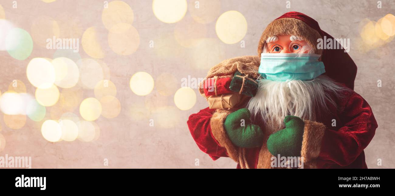 Giocattolo fittizio Babbo Natale con maschera protettiva per pandemie Covid-19, fuoco selettivo Foto Stock