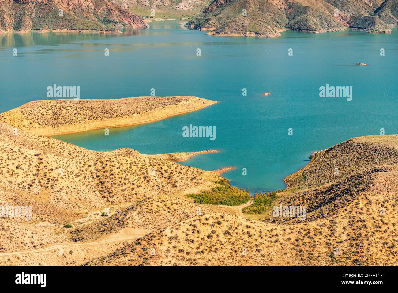 Vista su una gola di montagna con un serbatoio d'acqua di colore turchese brillante. Il fiume Azat in Armenia e montagne aride sullo sfondo. Foto Stock