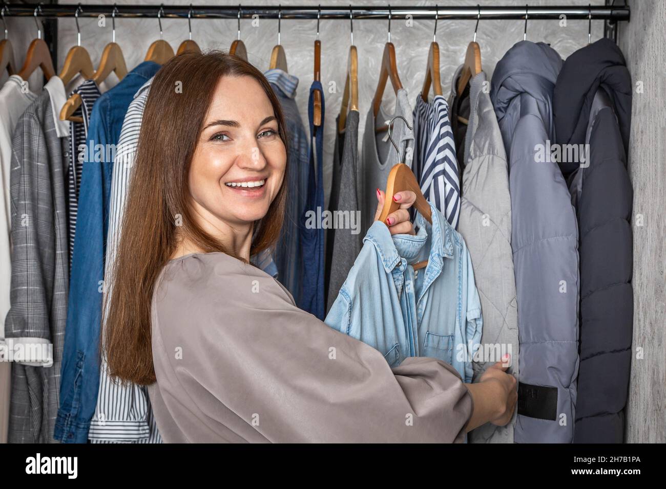 Ritratto felice rossa donna scelta abiti moderno comodo deposito organizzato capsule guardaroba Foto Stock