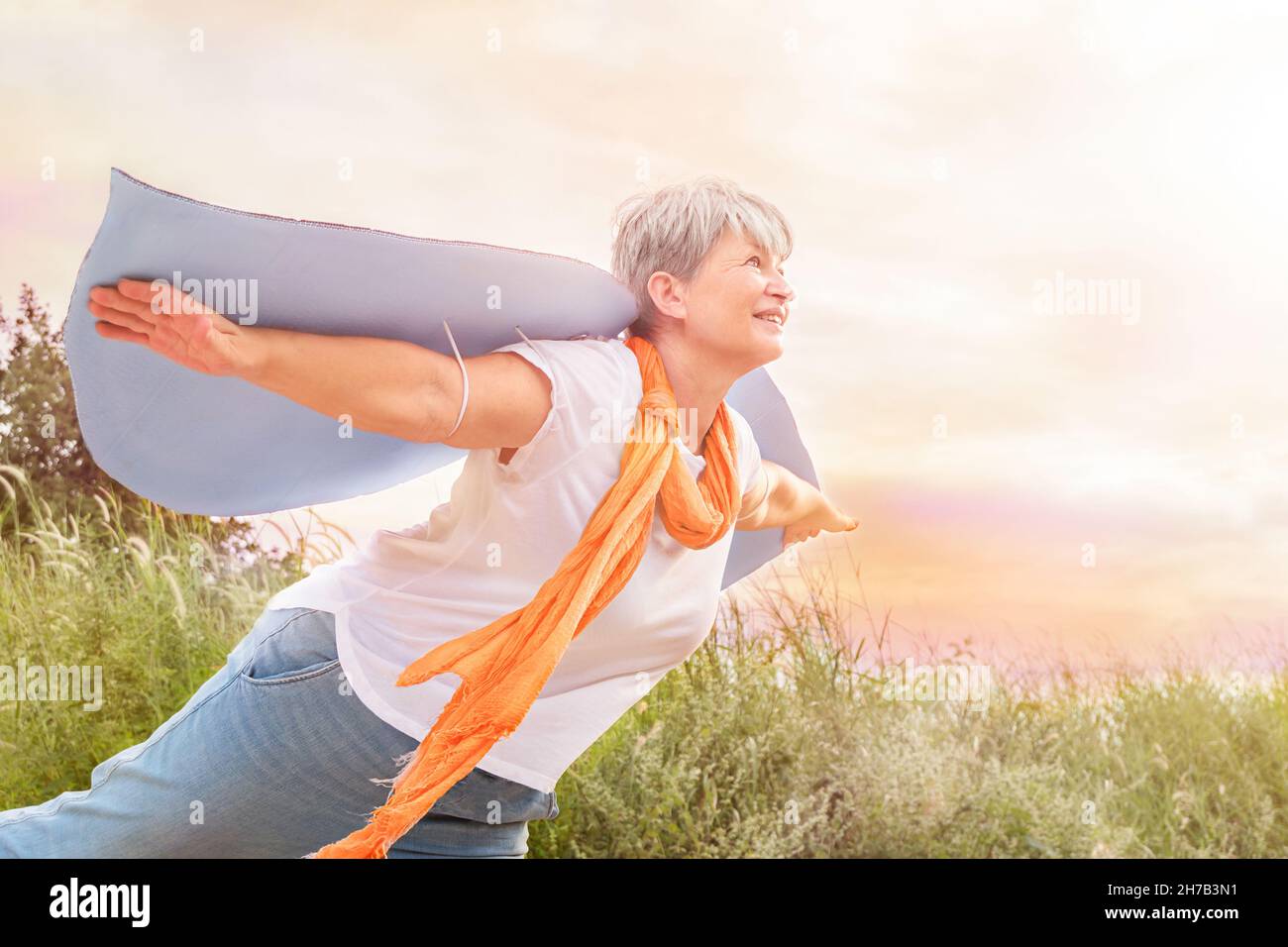 Libertà donna anziana in ali sul campo felice ha diffuso le sue braccia Foto Stock