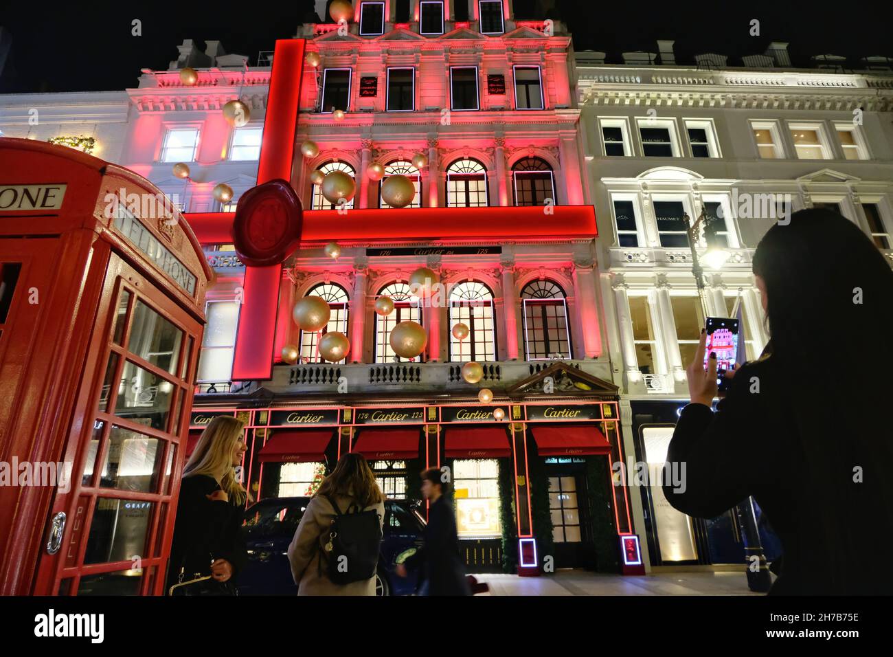 Londra, Regno Unito. Mostra musicale natalizia di Cartier illuminata di rosso in Old Bond Street. Foto Stock