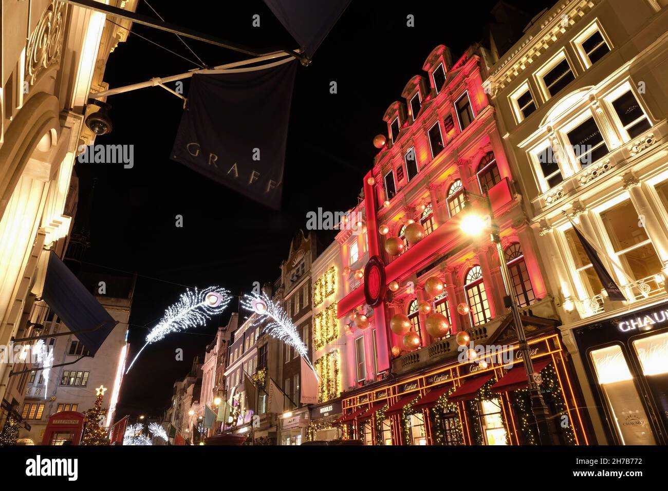 Londra, Regno Unito. Mostra musicale natalizia di Cartier illuminata di rosso in Old Bond Street. Foto Stock