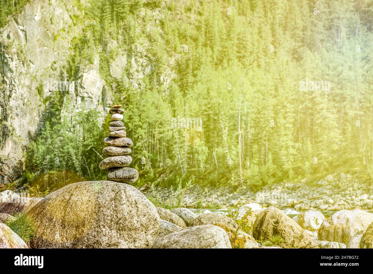 Cairn equilibrato su massi di pietra enormi sulle rive di un fiume di montagna. Zen piramide. Foto Stock