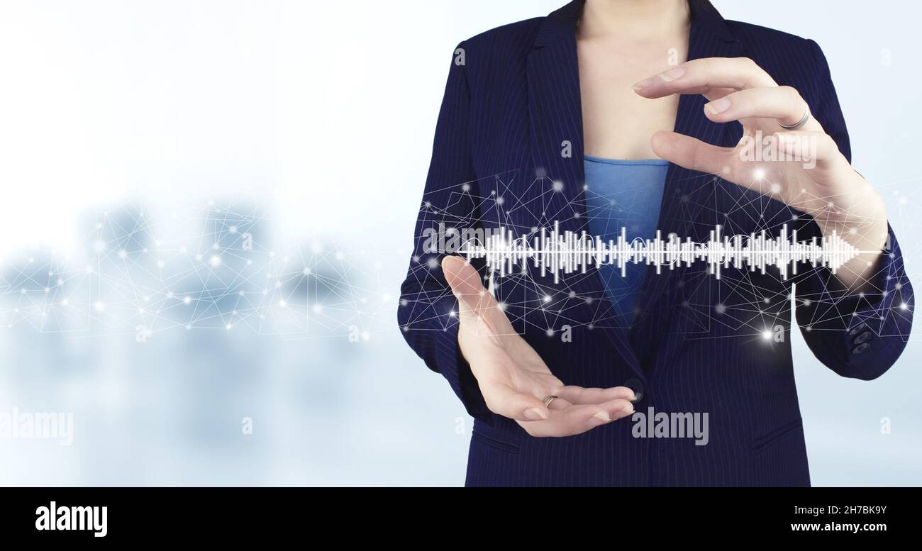 Concetto di musica con voi, software utilizzato per la registrazione. Due mani che tengono traccia del suono olografico virtuale, icona dell'onda con sfondo sfocato chiaro. Foto Stock