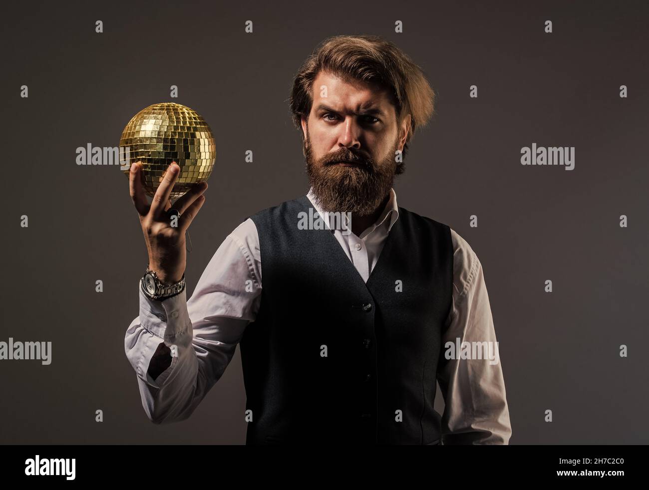 uomo con barba tenere specchio palla discoteca. concetto di festa aziendale. disco uomo in tuta con disco scintillante palla specchio. Il signor discoball. Discoteca super cool Foto Stock