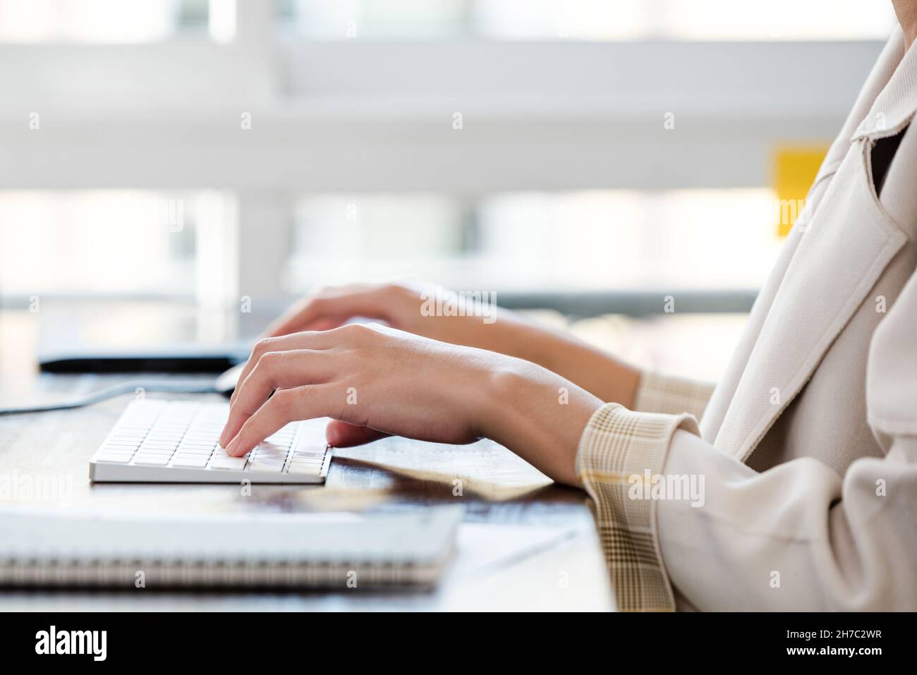 L'impiegato dell'ufficio femminile ha le mani che digitano sulla tastiera del calcolatore al tavolo Foto Stock