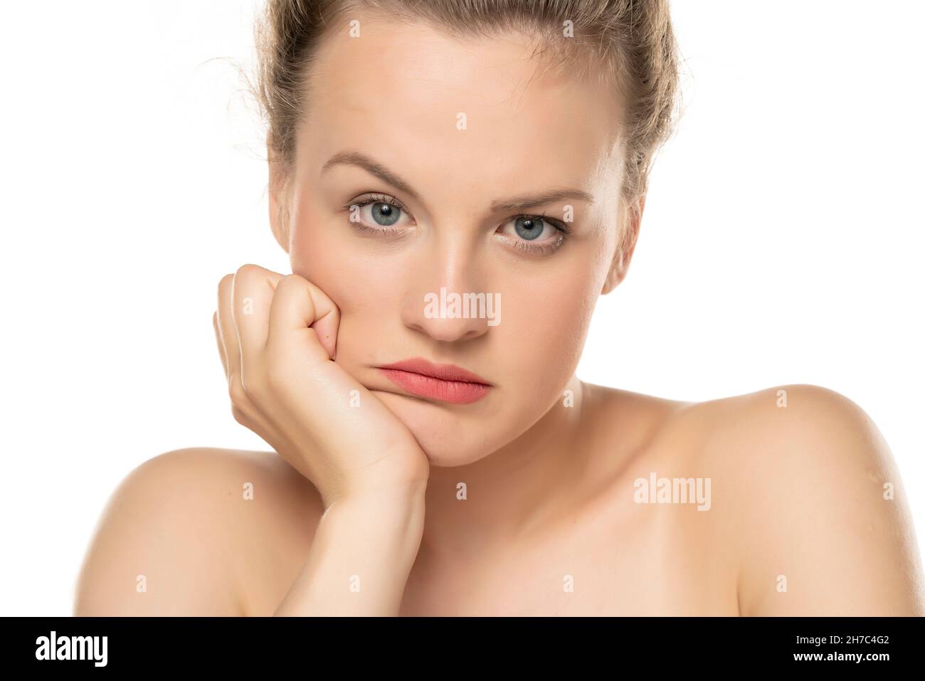 una giovane bella bionda guarda con incredulità sullo sfondo bianco Foto Stock