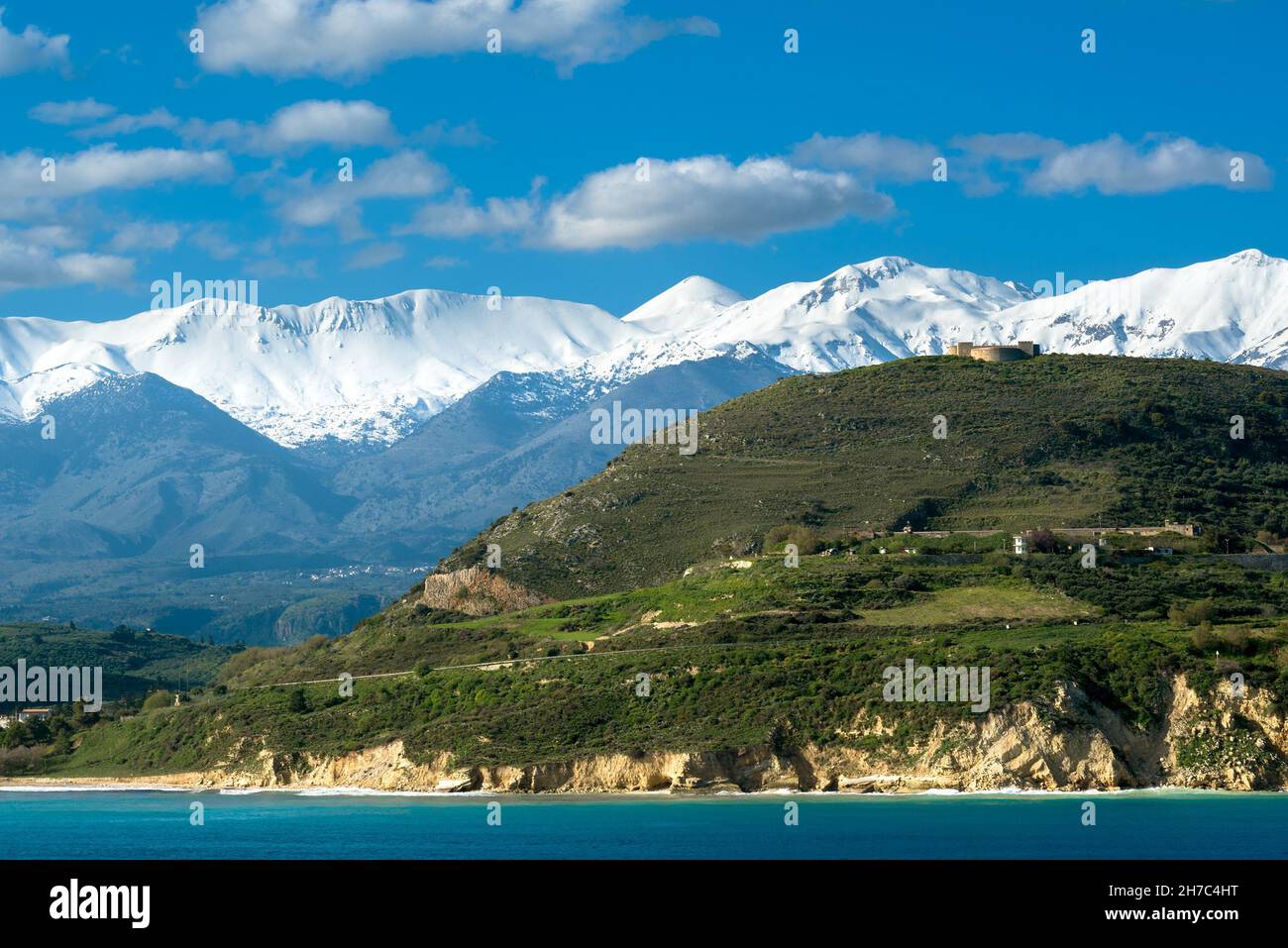 Fortezza sulla riva del mare contro montagne bianche Foto Stock