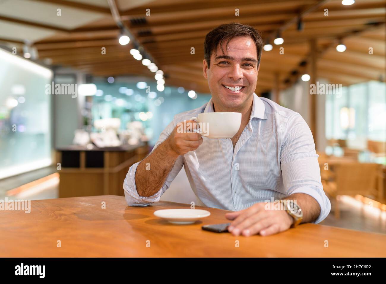 Ritratto di uomo d'affari persiano seduto al bar Foto Stock