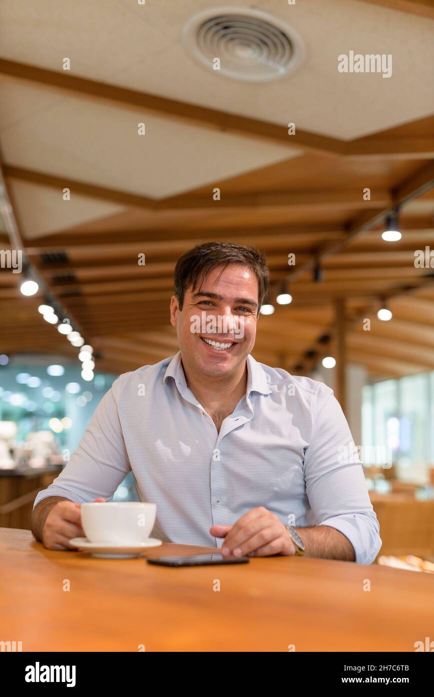 Ritratto di uomo d'affari persiano seduto al bar Foto Stock