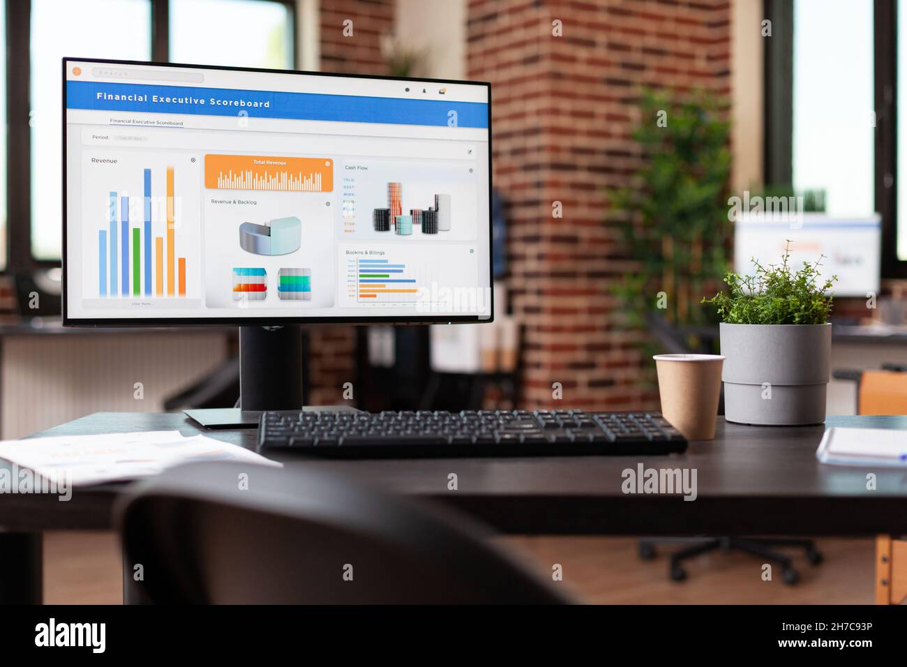 Computer con dati della società finanziaria su carte in ufficio. Spazio aziendale vuoto con analisi economiche che seguono la tendenza dei tassi sul monitor per fare investimenti per lo sviluppo dell'organizzazione. Foto Stock