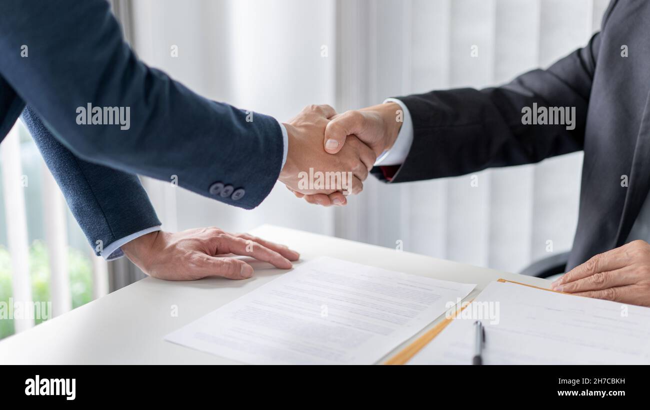 Concetto di legge il avvocato e l'uomo d'affari scuotendo le loro mani fermamente per aver fatto il loro lavoro bene. Foto Stock