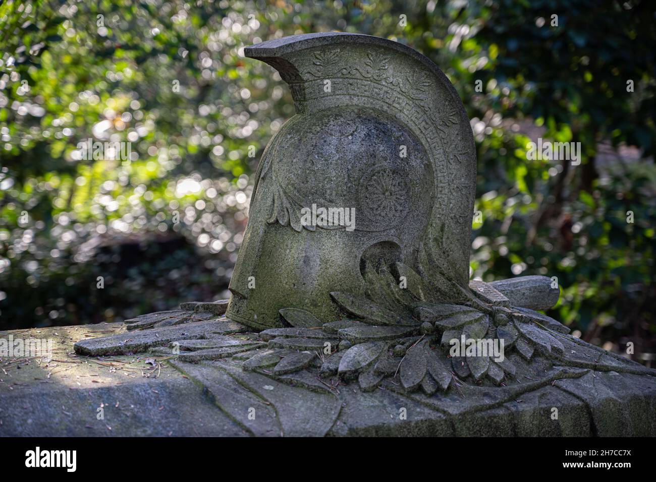tomba di guerra su un cimitero tedesco decorato con pietra di casco romano con spada e allori Foto Stock