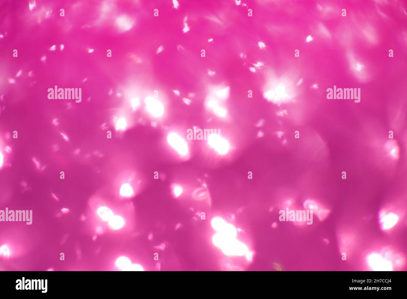 Glitter rosa, effetto sfocato. I cerchi luminosi per le vacanze vengono creati a partire dal bokeh nella fotocamera e nell'obiettivo. Sfondo per il design. Foto Stock