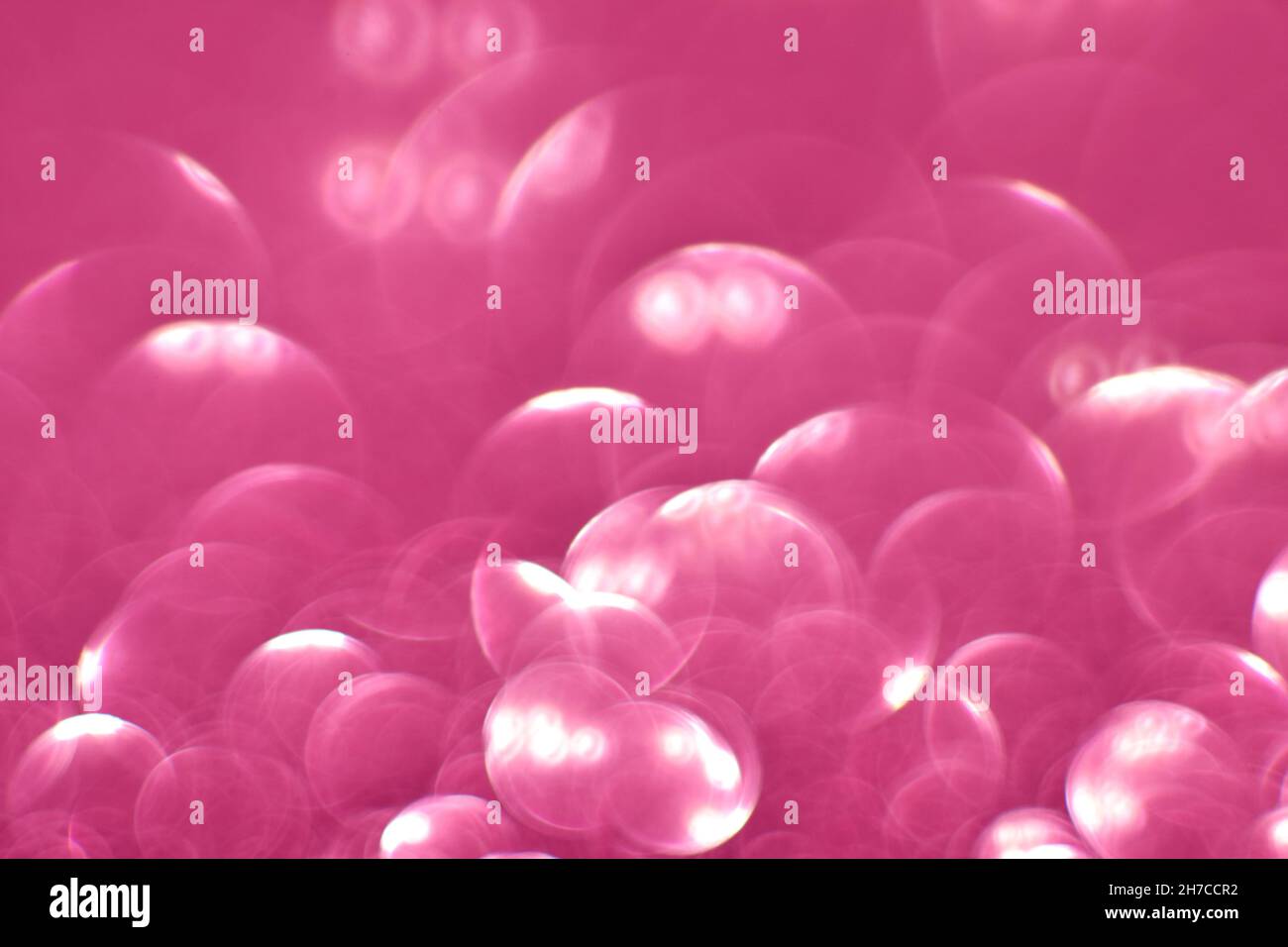 Glitter rosa, effetto sfocato. I cerchi luminosi per le vacanze vengono creati a partire dal bokeh nella fotocamera e nell'obiettivo. Sfondo per il design. Foto Stock