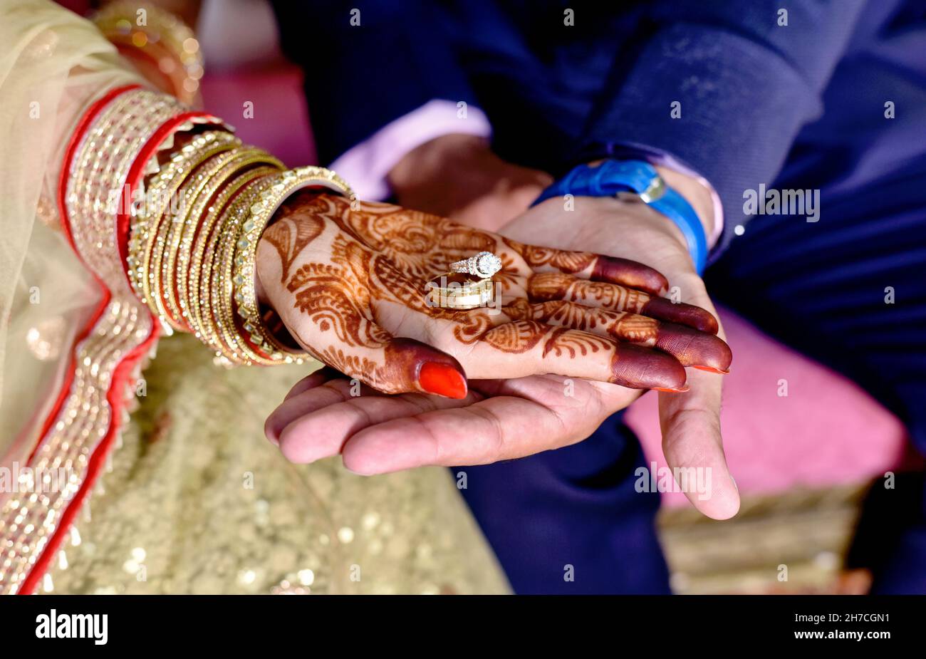 La sposa e le mani dello sposo che tengono & che mostrano gli anelli dei monili di cerimonia nuziale Foto Stock