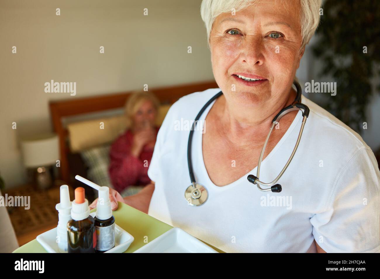 Donna del servizio di assistenza infermieristica con gocce sul vassoio in casa di riposo o a casa Foto Stock