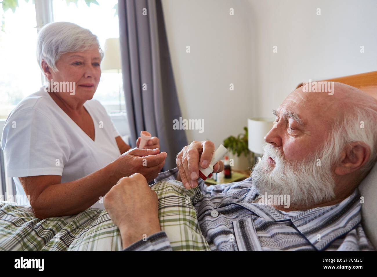 Senior come paziente con asma riceve cortisone spray da infermiere geriatrico nella casa di cura Foto Stock