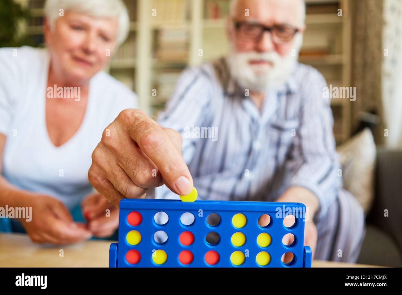 Gli anziani giocano il gioco di strategia quattro vittorie nel paese come teaser del cervello e jogging del cervello Foto Stock