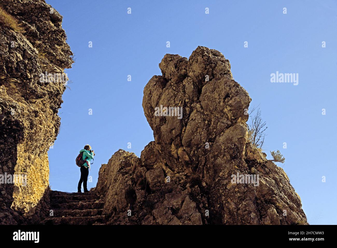 Donna scatta una foto sul sentiero per la grotta vergine, Francia, Provenza, Alpi dell'alta Provenza, Moustiers sainte Marie Foto Stock