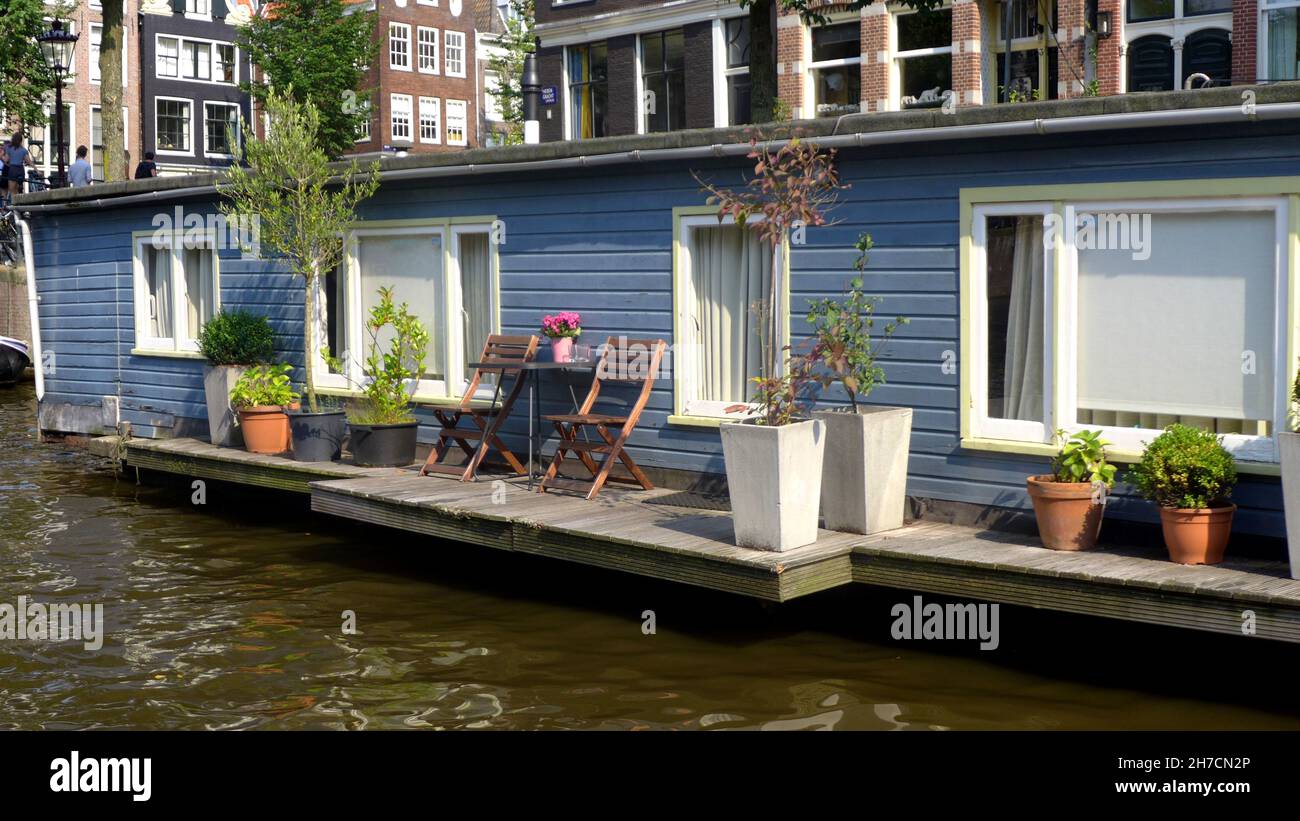 Casa galleggiante con veranda e piante in vaso sul canale , Olanda, Amsterdam Foto Stock