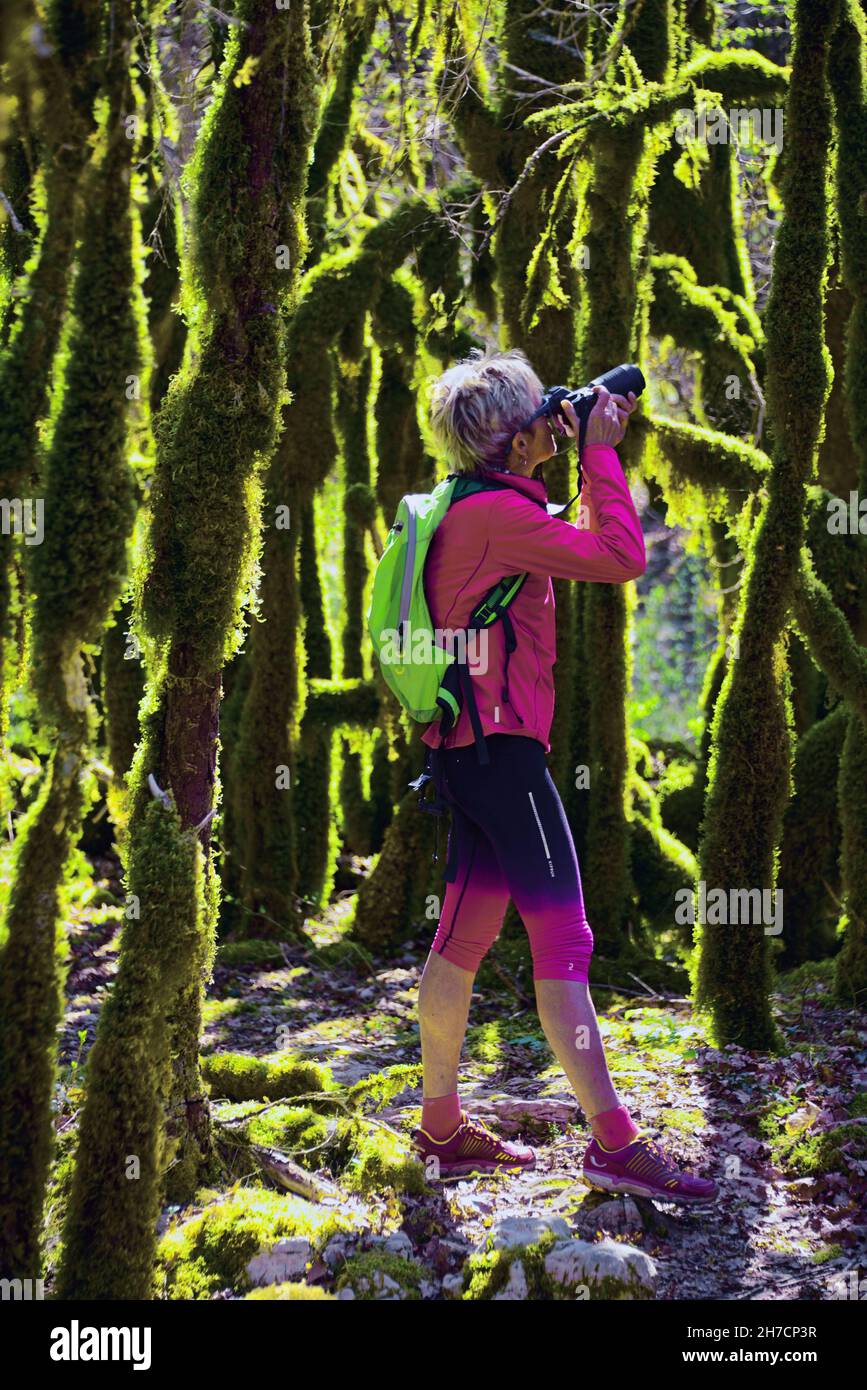 Donna scatta foto in una foresta di mosy vicino al lago di Vouglan, Francia, Giura, Moirans en Montagne Foto Stock