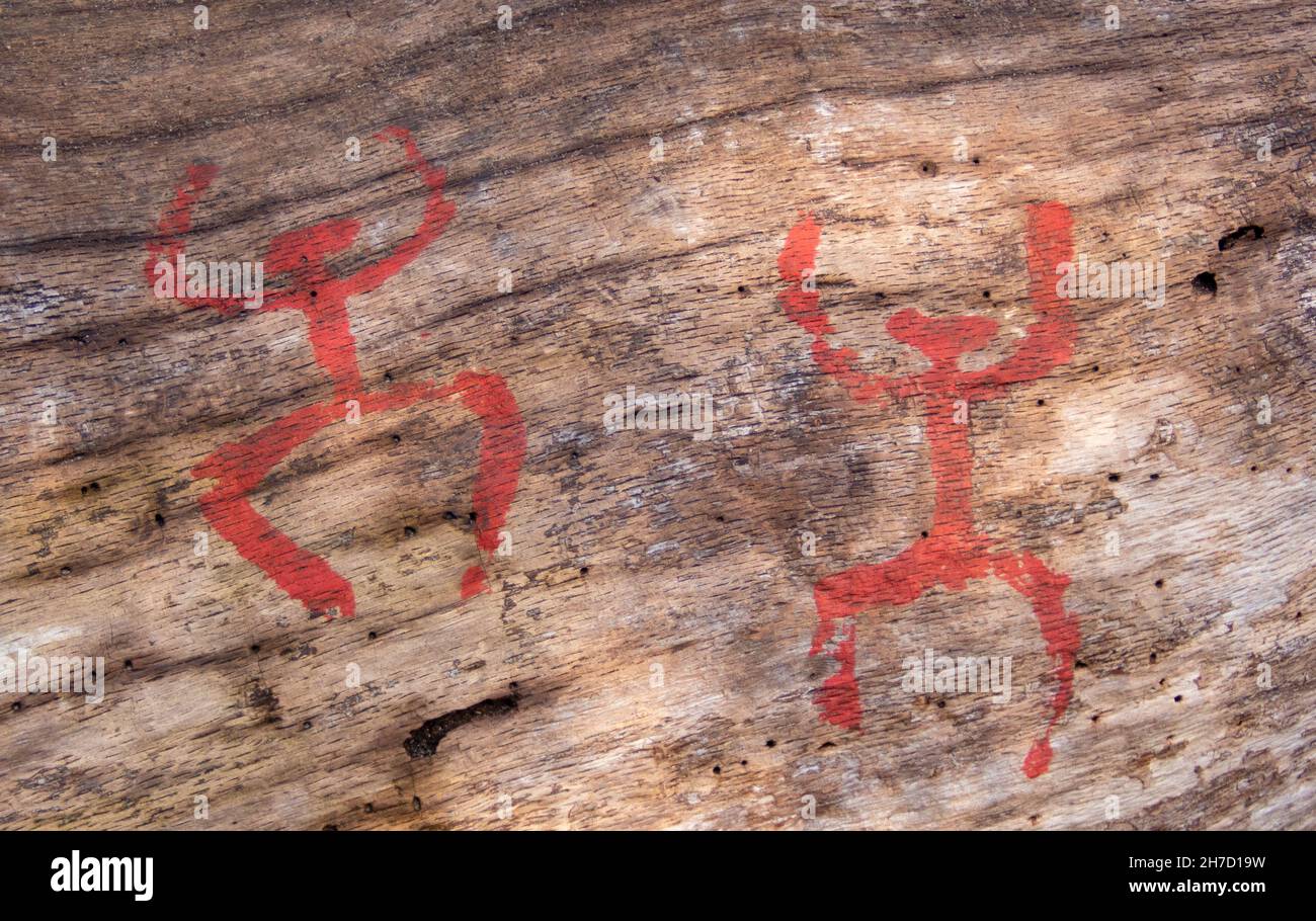 Scherzo antico moderno: Figure della nuova età della pietra dipinte su un vecchio tronco a Grunewald Foto Stock