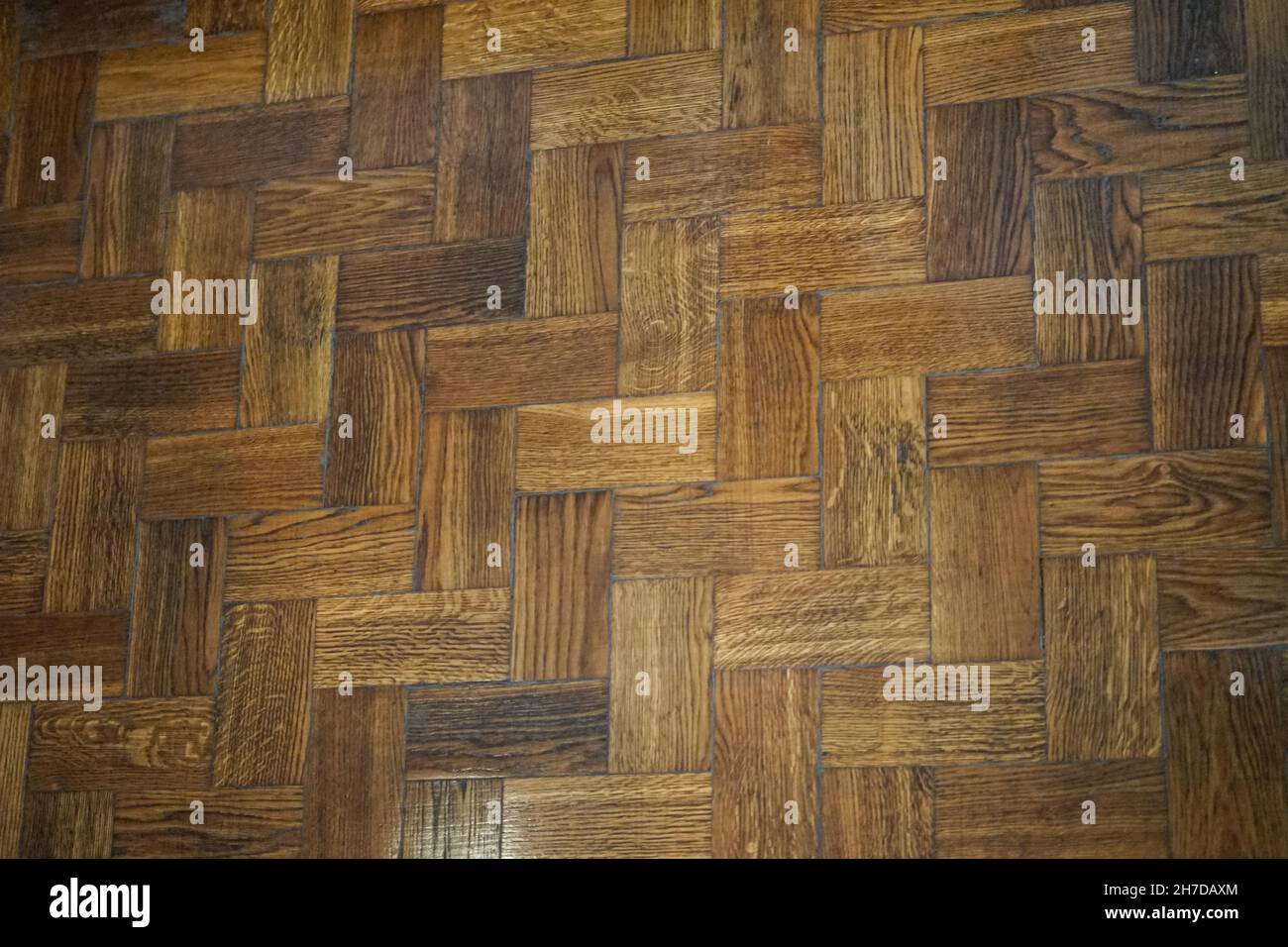 sfondo di pavimenti in legno a spina di pesce composti da assi di colore diverso. Foto Stock