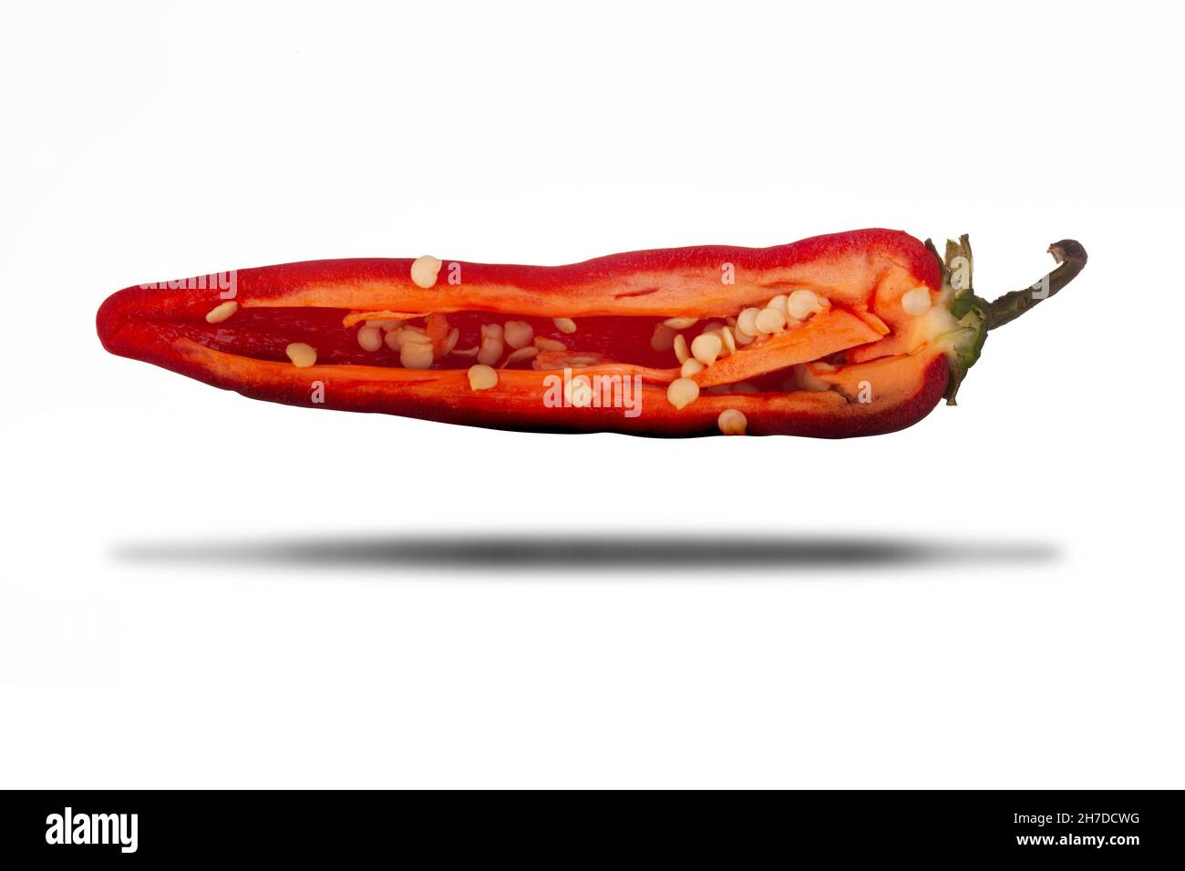 Peperoncino rosso caldo tagliato a fette a metà da vicino isolato su sfondo bianco con ombra Foto Stock