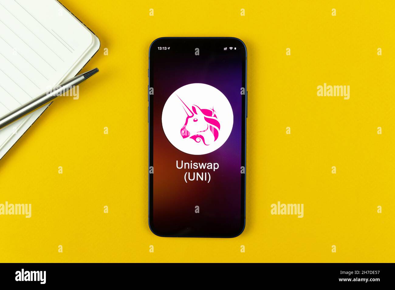 Simbolo Uniswap UNI. Commercio con criptovaluta, denaro digitale e virtuale, banca con concetto di telefonia mobile. Area di lavoro, vista dal piano del tavolo Foto Stock