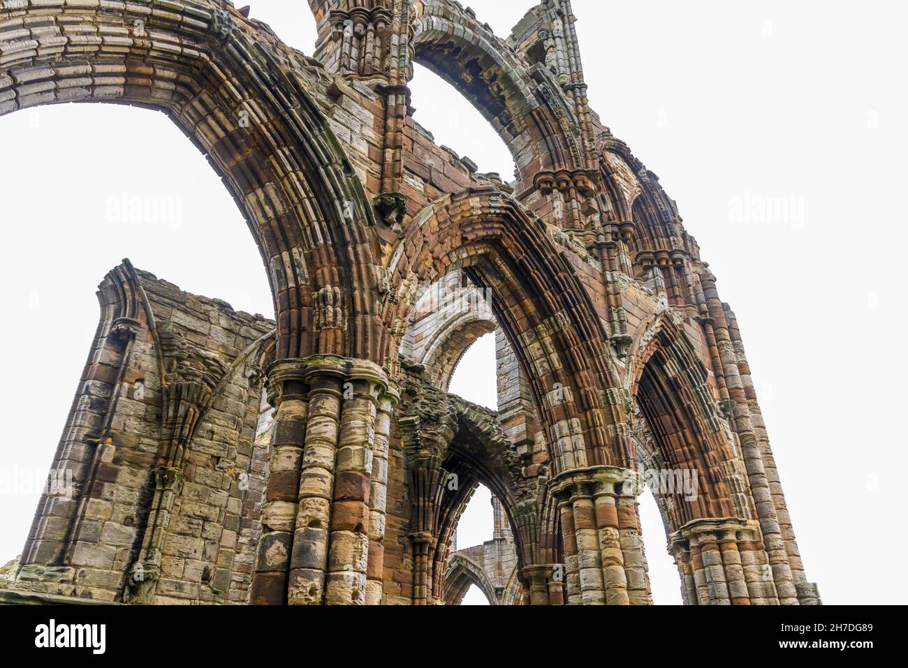 Dettaglio degli archi alle rovine dell'Abbazia di Whitby, un monastero cristiano del VII secolo che divenne in seguito un'abbazia benedettina. Foto Stock