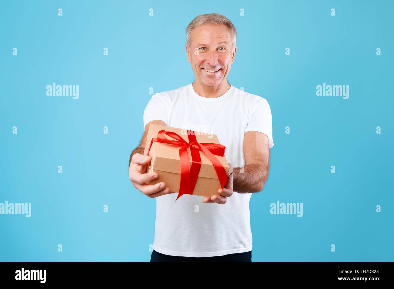 Mature Man Holding e regalo di Natale a Studio Foto Stock