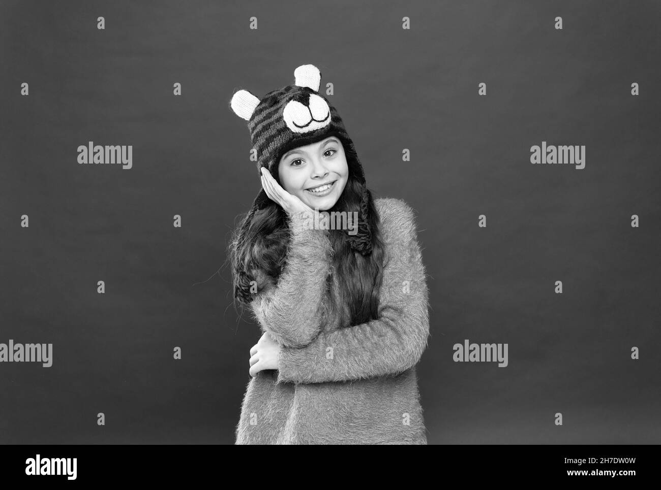 ragazza sorridente in accogliente caldo indossare cappello invernale, daydreamer Foto Stock