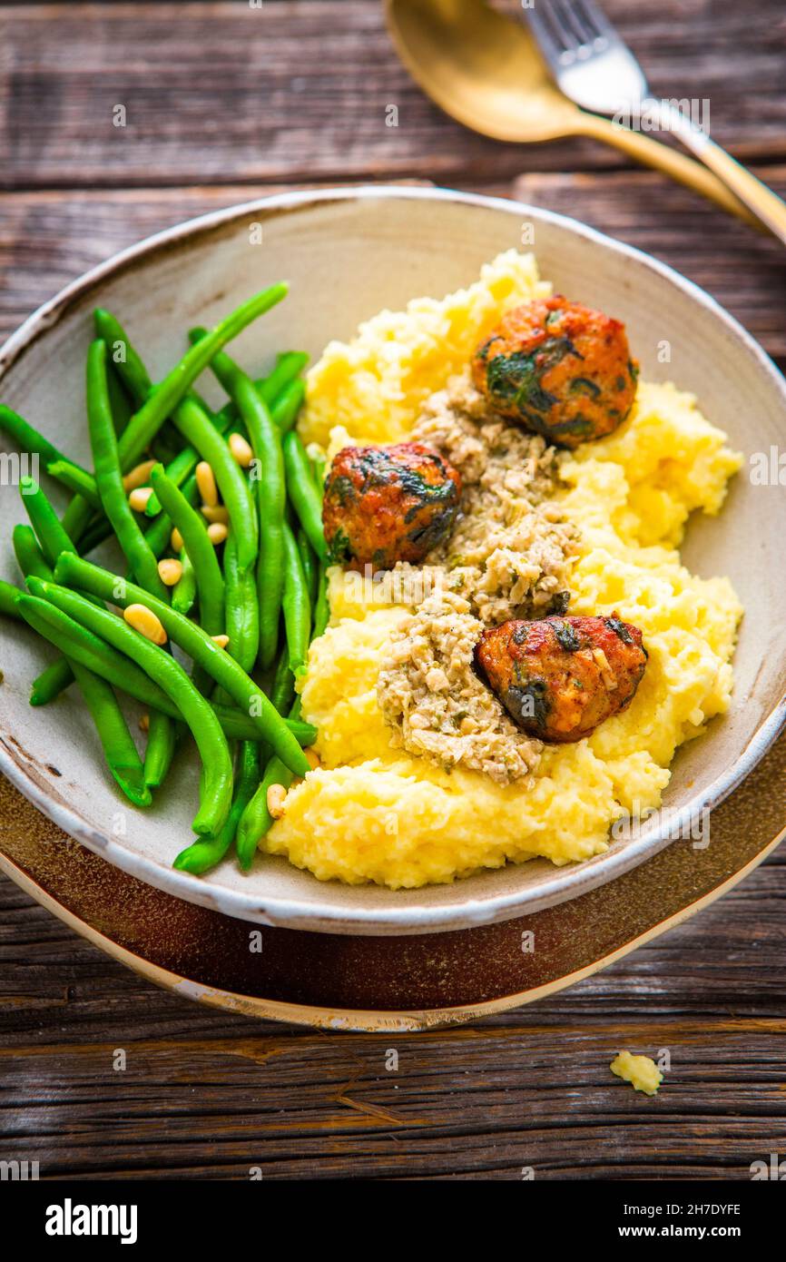 Polenta con polpette di pollo e spinaci e fagioli verdi Foto Stock